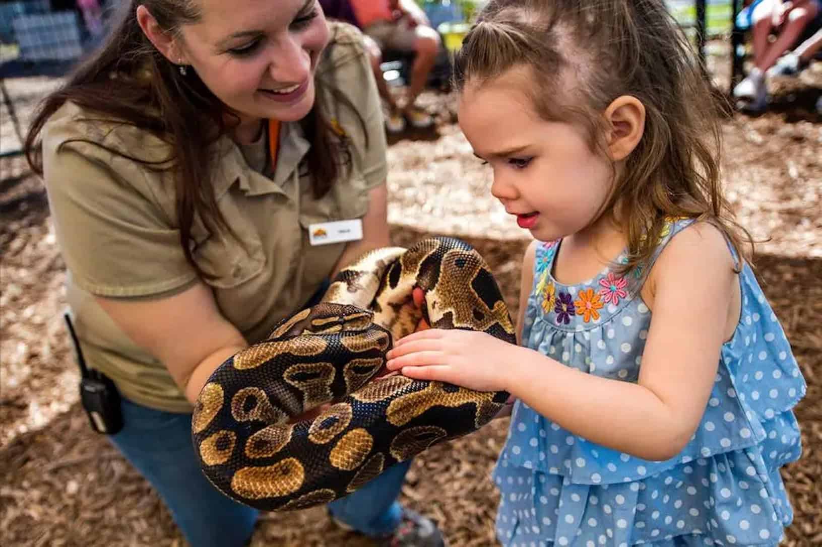 woman and girl holding a snake